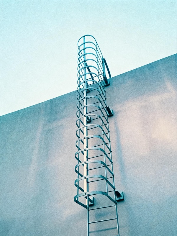 Fixed ladder with safety cage configuration